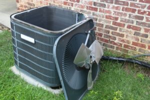 When To Replace Your Old AC - Fan off the top of Air Conditioner Condenser during maintenance.