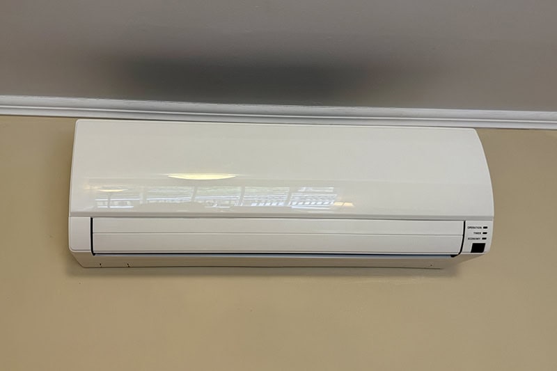 A standard white wall-mounted ductless mini-split air conditioning unit.