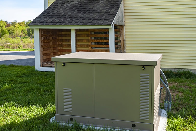 A whole-house standby generator installed on a concrete pad.