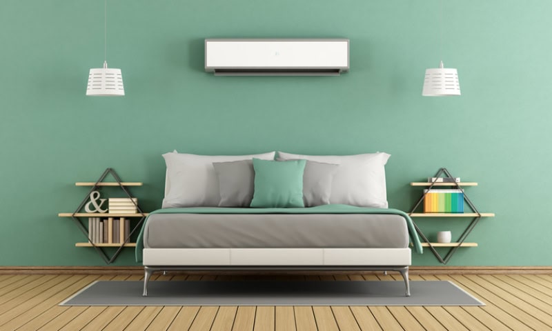 A wall-mounted mini-split air conditioning unit positioned above the bed.