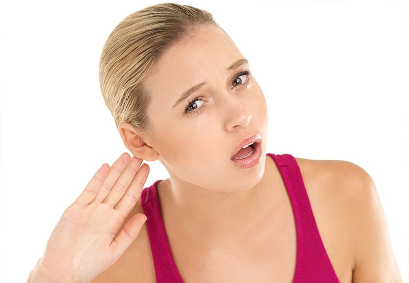A woman struggling to hear something.