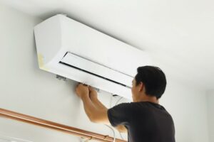 man installing ductless AC system.